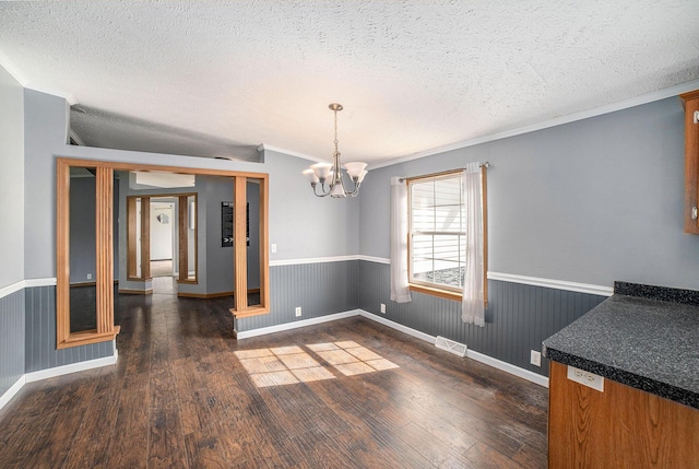 5355 W Remus Rd, Mount Pleasant, MI 48858 - unfurnished dining area with dark wood finished floors, a wainscoted wall, and a chandelier
