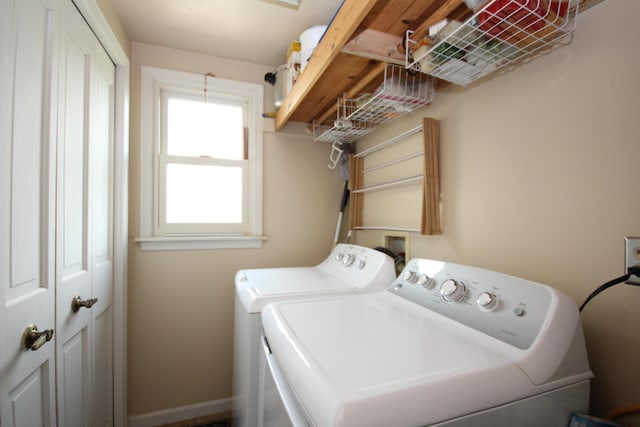 washroom featuring laundry area, washer and clothes dryer, and baseboards