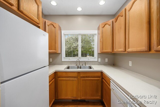 kitchen featuring recessed lighting, a sink, white appliances, and light countertops