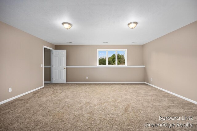 carpeted spare room with baseboards