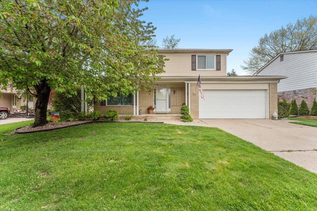 view of front facade with concrete driveway, a garage, a front lawn, and brick siding