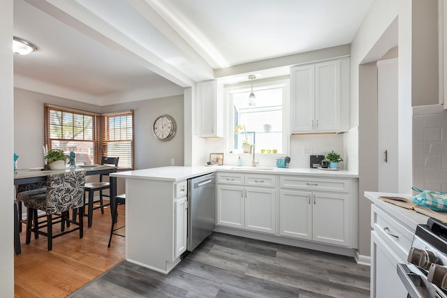 kitchen with appliances with stainless steel finishes, decorative backsplash, a peninsula, and white cabinets