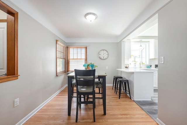 dining space with light wood-style floors and baseboards