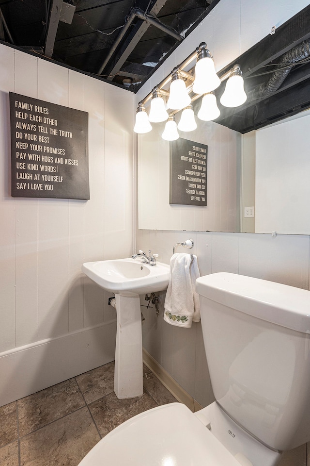 bathroom featuring stone finish floor and toilet