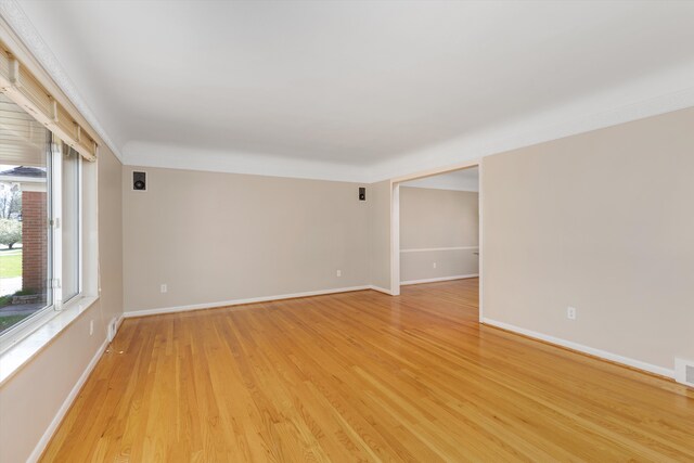 spare room with baseboards, visible vents, and light wood-style floors