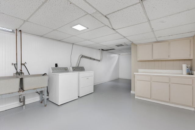 washroom with baseboards, cabinet space, and washer and dryer