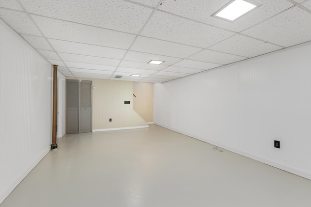 finished below grade area with baseboards and a paneled ceiling