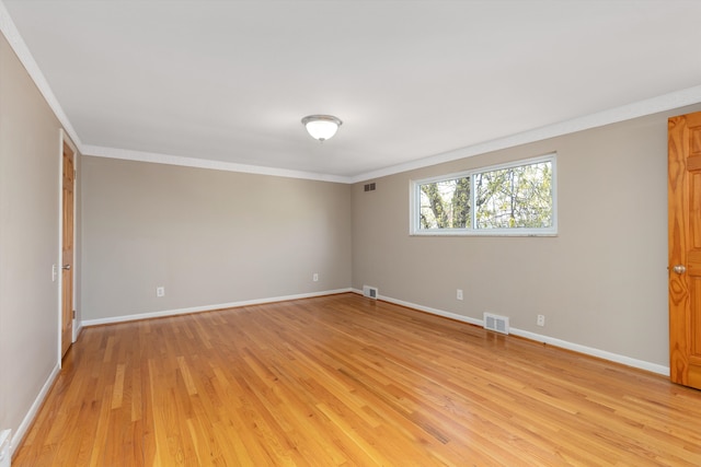 unfurnished room with visible vents, baseboards, crown molding, and light wood-type flooring