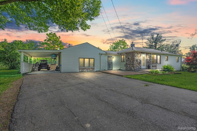 5304 E Frances Rd, Mount Morris, MI 48458 - mid-century modern home with driveway, a chimney, stone siding, a front yard, and a carport