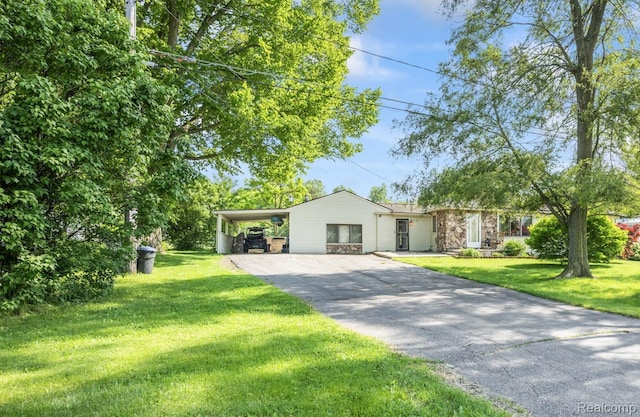 5304 E Frances Rd, Mount Morris, MI 48458 - view of front of home with asphalt driveway, an attached carport, stone siding, and a front yard