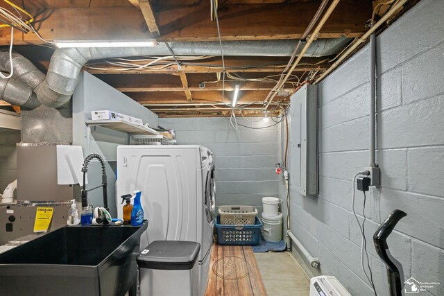 interior space with concrete block wall, washer / dryer, and light wood-style flooring
