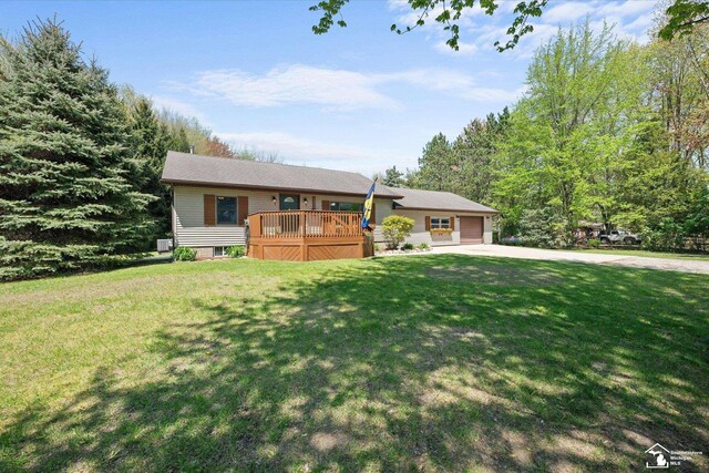 ranch-style house with an attached garage, concrete driveway, a deck, and a front yard