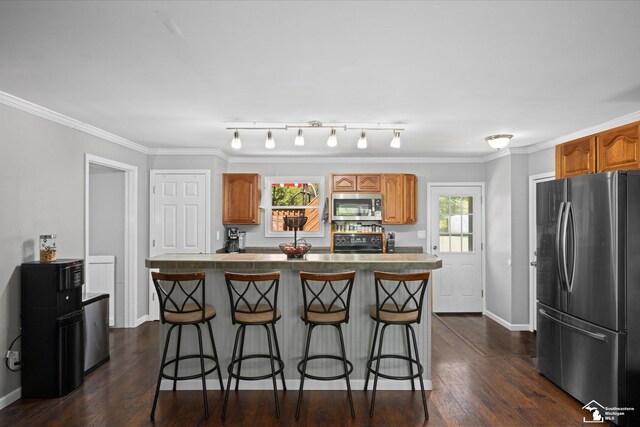 kitchen with baseboards, brown cabinets, a breakfast bar, and stainless steel appliances