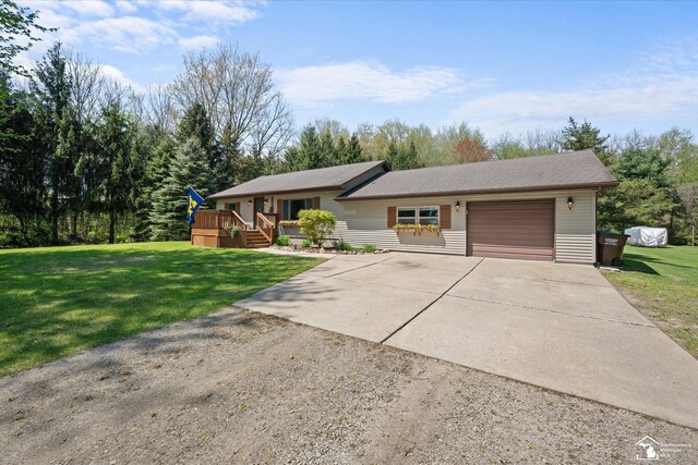 ranch-style home featuring an attached garage, driveway, and a front yard