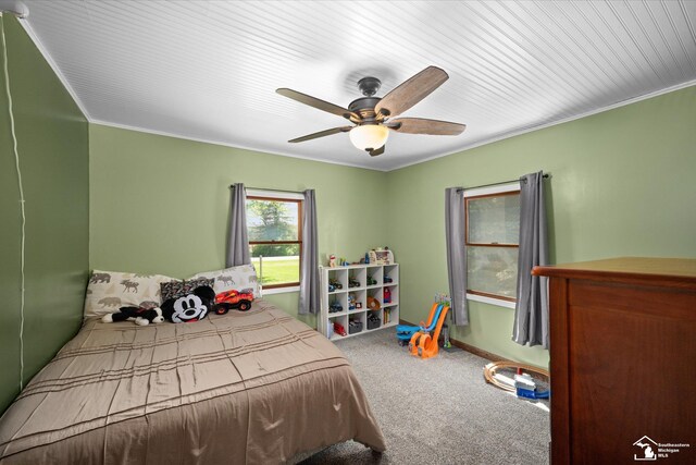 bedroom with a ceiling fan, baseboards, ornamental molding, and carpet