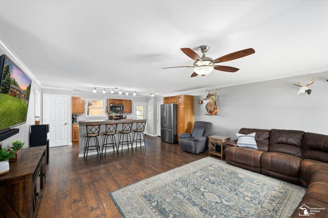 living room featuring ornamental molding, ceiling fan, and dark wood-style floors