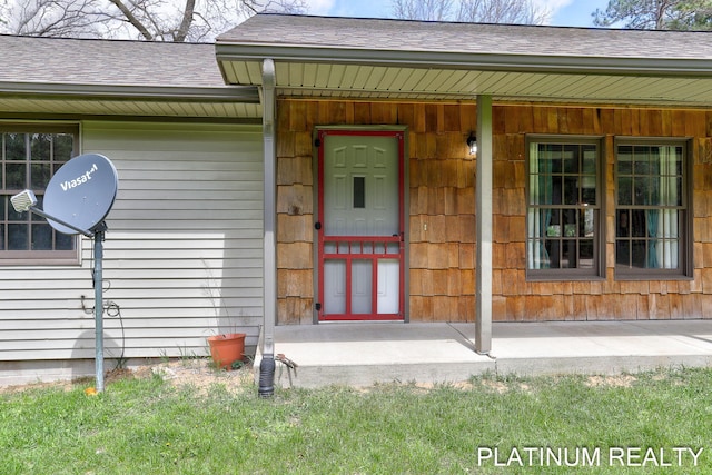 4334 Brunswick Rd, Holton, MI 49425 - doorway to property with roof with shingles and a porch