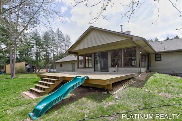4334 Brunswick Rd, Holton, MI 49425 - rear view of house with a deck, a yard, a playground, and a sunroom