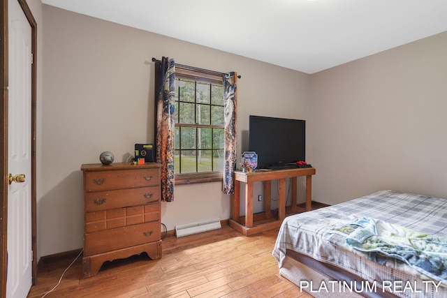 4334 Brunswick Rd, Holton, MI 49425 - bedroom with light wood-style floors and a baseboard heating unit