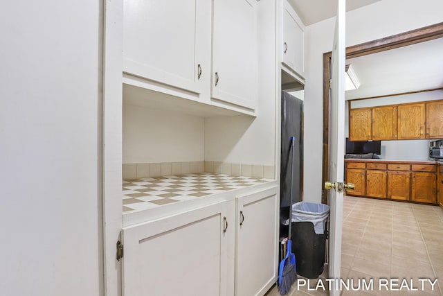 4334 Brunswick Rd, Holton, MI 49425 - laundry area with light tile patterned floors