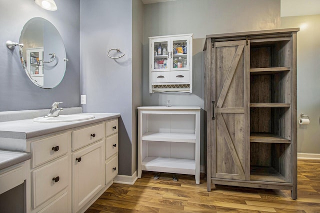 bathroom featuring vanity, baseboards, and wood finished floors