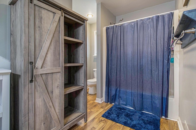 full bathroom with toilet, a shower with curtain, and wood finished floors