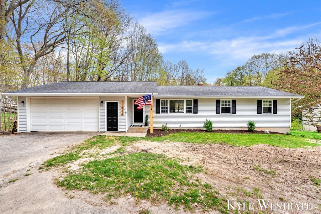 ranch-style home with an attached garage and aphalt driveway