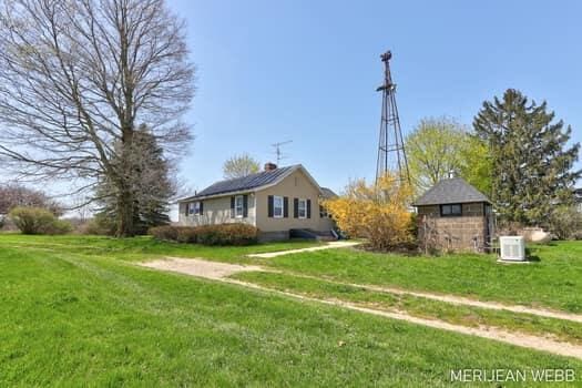 exterior space featuring a chimney, cooling unit, and a front yard
