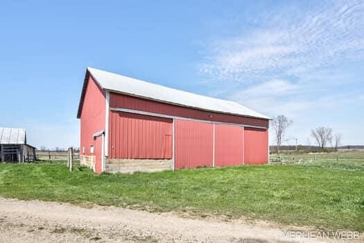 view of outbuilding with fence and an outbuilding