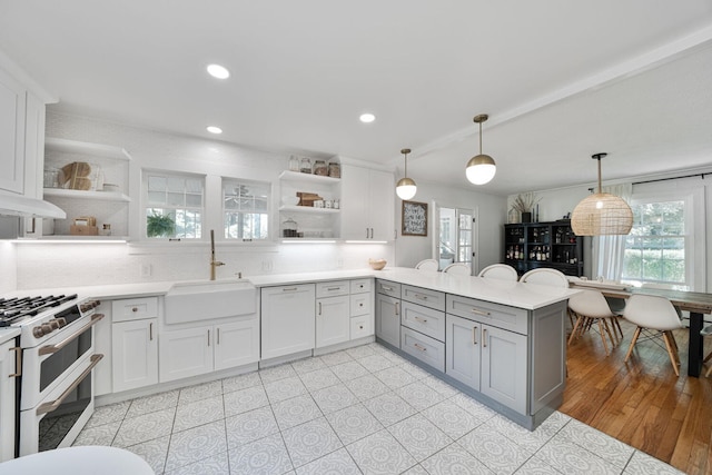 61412 Walnut St, Cassopolis, MI 49031 - kitchen with open shelves, a sink, range with two ovens, a peninsula, and gray cabinetry