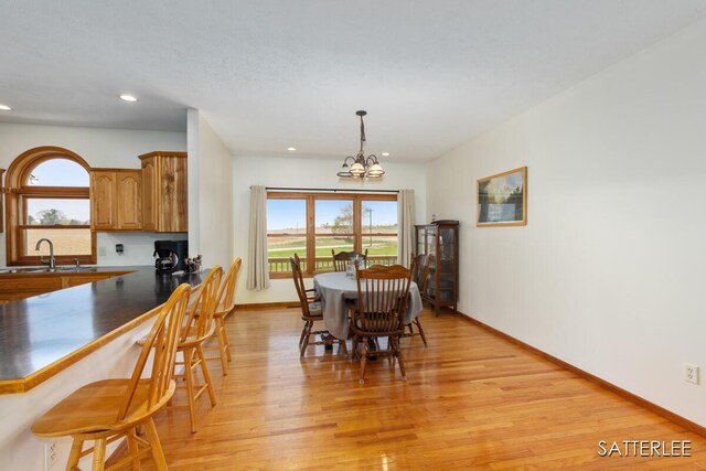dining space featuring a healthy amount of sunlight, recessed lighting, light wood finished floors, and a notable chandelier