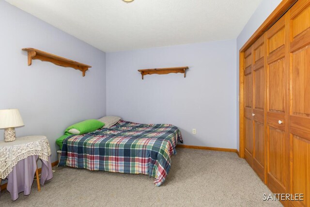 carpeted bedroom with baseboards and a closet