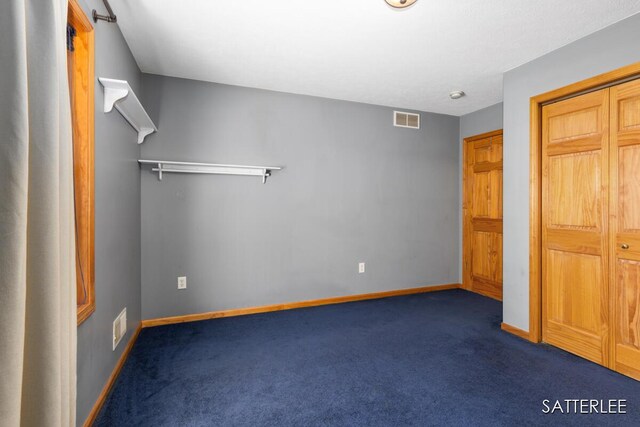 unfurnished bedroom with carpet floors, baseboards, and visible vents