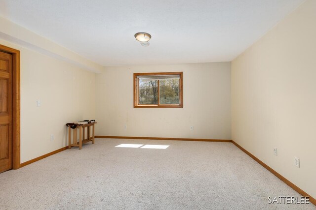 unfurnished room with baseboards and light colored carpet