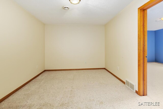spare room with baseboards, visible vents, and carpet