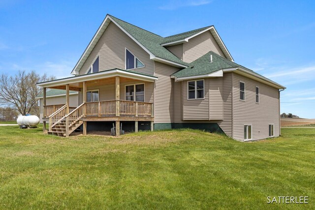 back of property featuring a porch, a shingled roof, and a yard