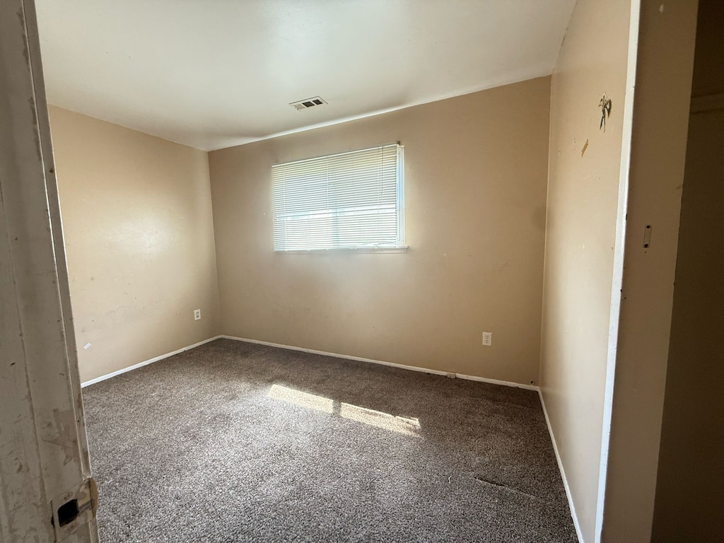 unfurnished room with carpet and baseboards