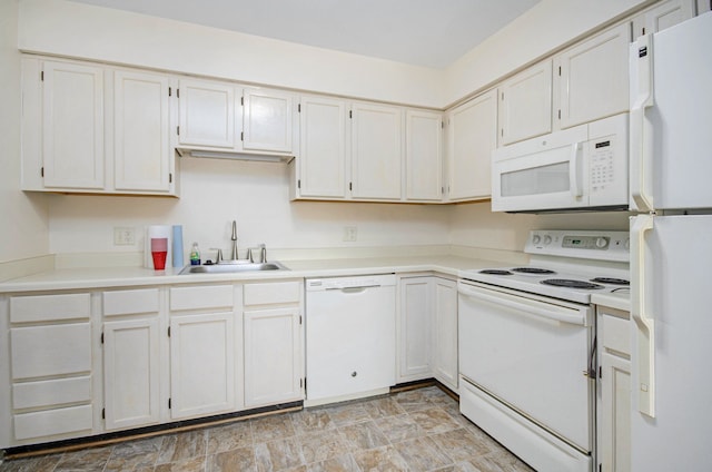 kitchen featuring a sink, light countertops, stone finish floor, and white appliances