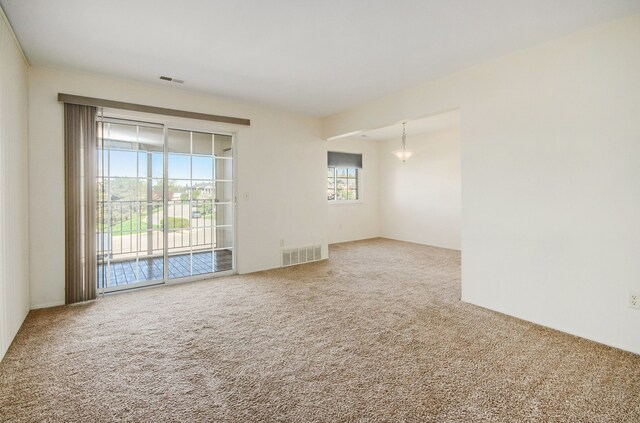 spare room featuring carpet floors and visible vents