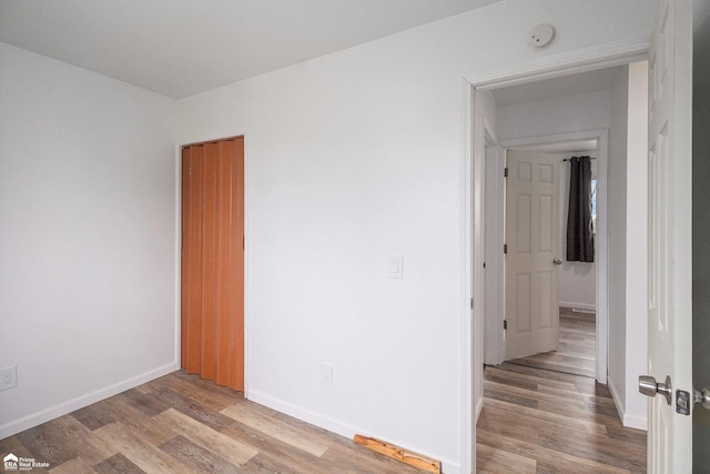 unfurnished room featuring baseboards and light wood-type flooring