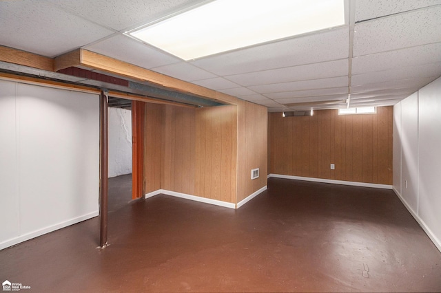 basement with baseboards, visible vents, and a paneled ceiling