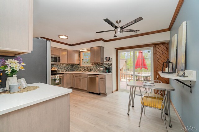 kitchen with crown molding, ceiling fan, appliances with stainless steel finishes, and tasteful backsplash