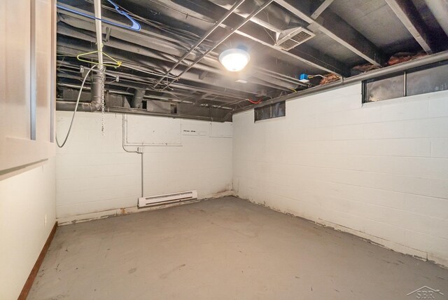 unfinished below grade area featuring visible vents and a baseboard heating unit