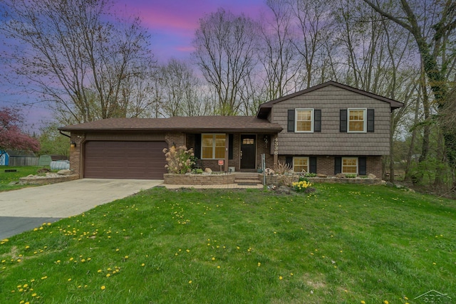 split level home with an attached garage, brick siding, a front yard, concrete driveway, and covered porch