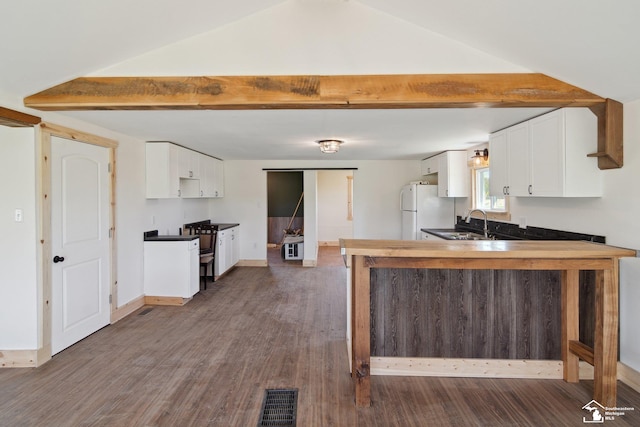 13280 Burt Rd, Pittsford, MI 49271 - kitchen with white cabinets, dark wood finished floors, freestanding refrigerator, a peninsula, and visible vents