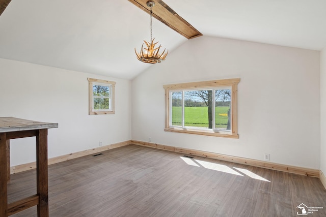 13280 Burt Rd, Pittsford, MI 49271 - interior space featuring vaulted ceiling with beams, baseboards, wood finished floors, and a notable chandelier