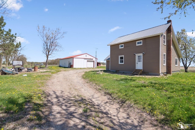 13280 Burt Rd, Pittsford, MI 49271 - exterior space featuring driveway, metal roof, an outbuilding, a garage, and entry steps