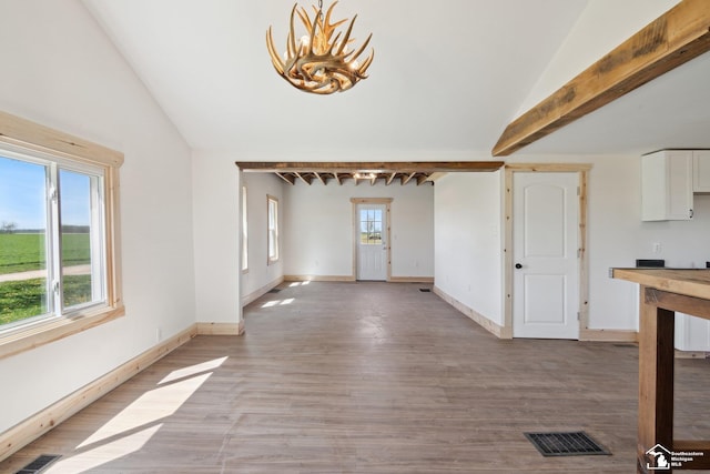13280 Burt Rd, Pittsford, MI 49271 - unfurnished dining area featuring light wood-style floors, baseboards, vaulted ceiling, and visible vents