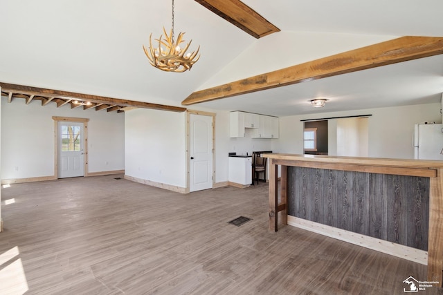 13280 Burt Rd, Pittsford, MI 49271 - kitchen with visible vents, baseboards, freestanding refrigerator, a notable chandelier, and white cabinetry