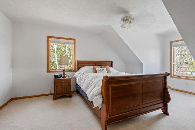 7734 N Shore Ct, Grawn, MI 49637 - bedroom with baseboards, ceiling fan, vaulted ceiling, and light colored carpet